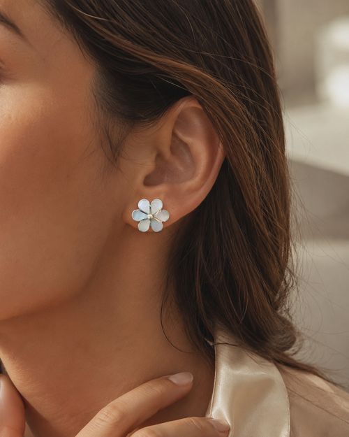 Mother of pearl flower stud earrings worn on ear showing delicate 0.7 inch floral design
