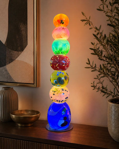 Colorful handblown glass light tower displayed as illuminated art lighting in a home setting