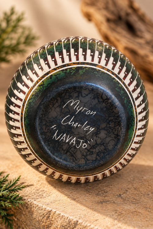 Signed underside of Myron Charley Navajo pottery showing the artist name and Navajo inscription