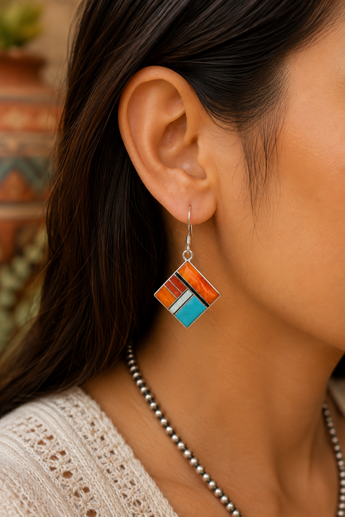 Native American stone inlay earrings with orange and red spiny oyster, turquoise, cultured opal and black jade shown on ear