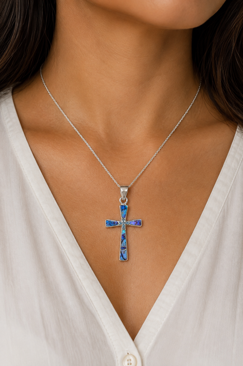 Native American sterling silver cross pendant with blue spiderweb opal inlay shown on necklace