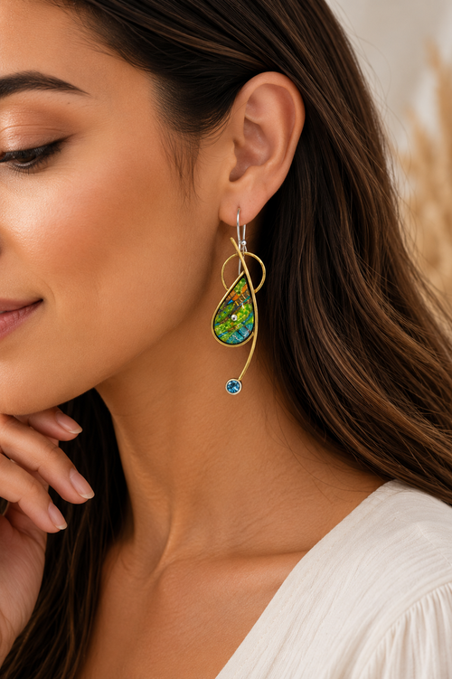 Nature-inspired green and blue earrings with blue topaz shown on model ear.