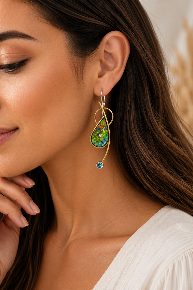Nature-inspired green and blue earrings with blue topaz shown on model ear.