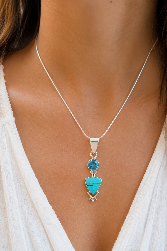 Luxury lifestyle photo of an authentic Navajo Blue Topaz and Arizona Kingman Turquoise pendant necklace handcrafted in sterling silver.