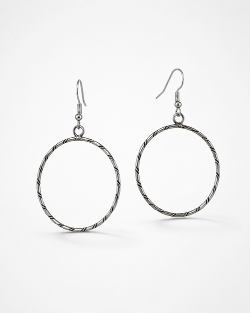Navajo sterling silver hoop earrings on a clean white background, handmade by Caroline Tsosie.