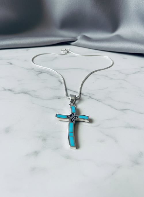 Close-up of an authentic Navajo stone inlay cross pendant featuring Arizona Blue Turquoise set in solid sterling silver with traditional Southwestern craftsmanship.