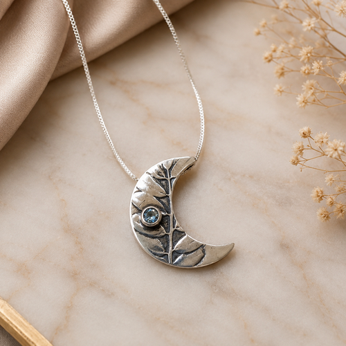 One-of-a-kind crescent moon necklace handcrafted in sterling silver with aquamarine gemstone in Sedona Arizona