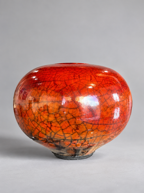 One-of-a-kind ferric chloride Raku orb by Bob Smith with rich red and amber tones, dark crackle lines and straw-fired surface markings