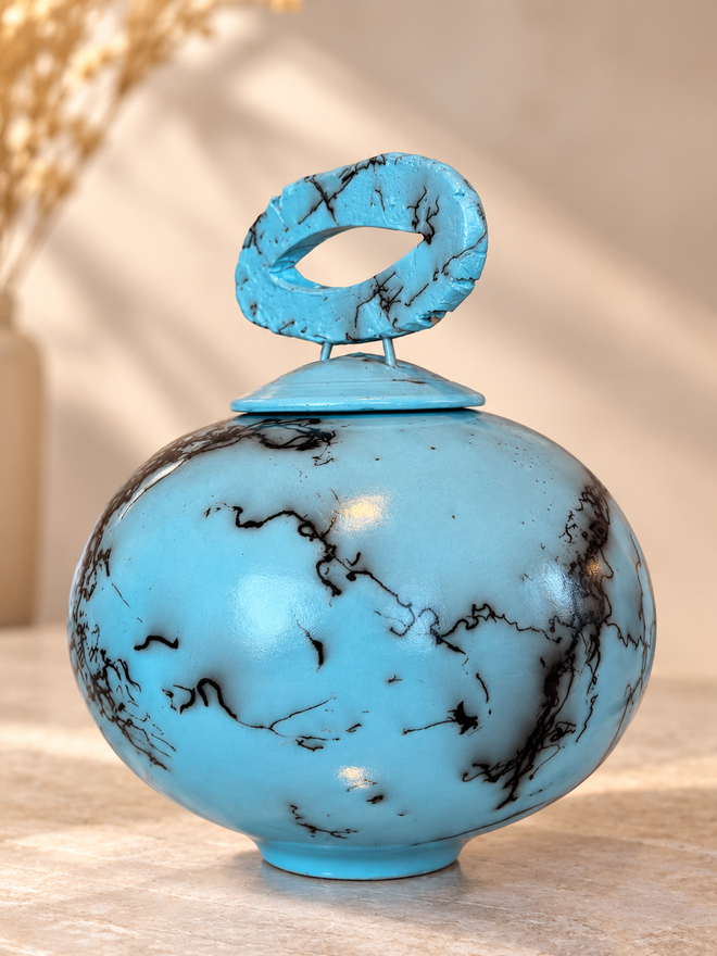 Sculptural turquoise raku lidded vessel with open oval handle and natural black horsehair design