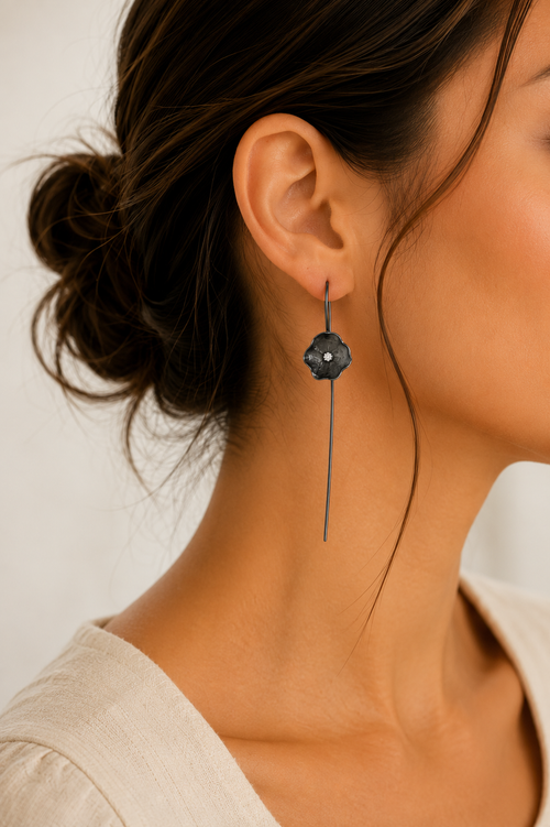 Model wearing handcrafted oxidized sterling silver flower earrings with long French hook ear wires and brilliant 2mm cubic zirconia.