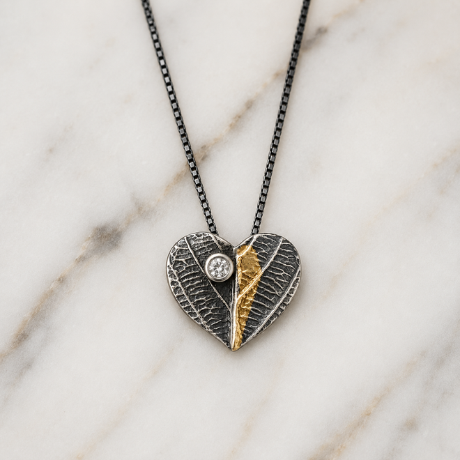 Close-up detail of handmade oxidized sterling silver heart necklace with 24k gold and cubic zirconia handcrafted in Sedona Arizona