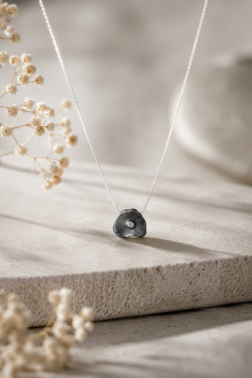 Handmade oxidized sterling silver petal pendant necklace with sparkling cubic zirconia, elegant minimalist artisan jewelry for women.