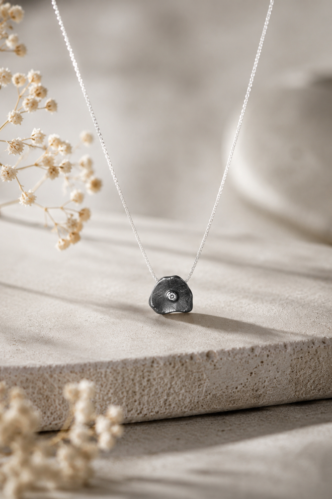 Handmade oxidized sterling silver petal pendant necklace with sparkling cubic zirconia, elegant minimalist artisan jewelry for women.