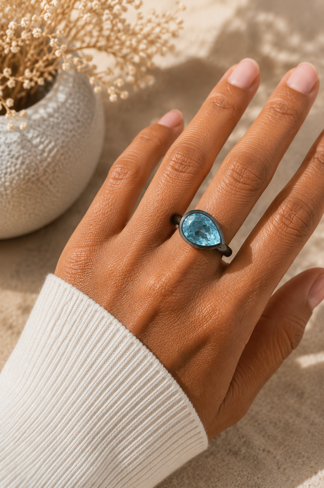 Handmade pear Blue Topaz ring worn on hand showcasing an 11x8mm natural Blue Topaz set in oxidized sterling silver with a contemporary artisan design.