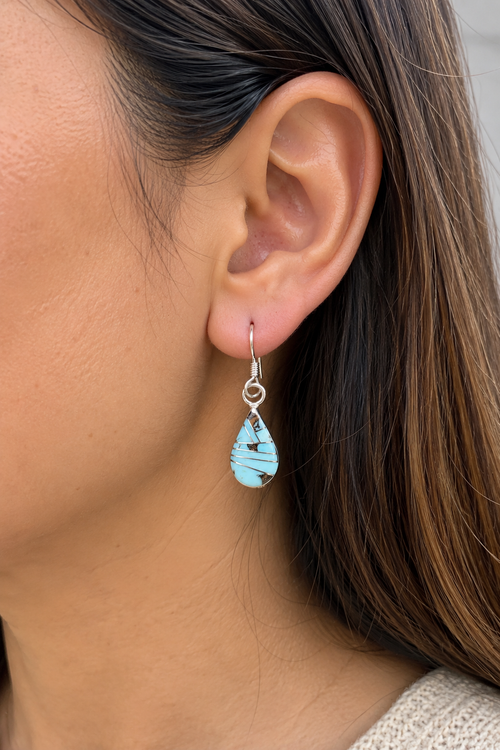 Model wearing petite Golden Hills turquoise sterling silver earrings, measuring approximately 1 inch long and 1/4 inch wide.