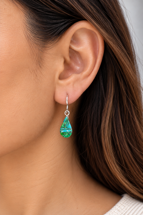Model wearing petite Sonoran turquoise dangle earrings in sterling silver, featuring green and blue geometric stone inlay, approximately 1 inch long.