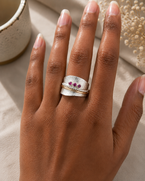 Rhodolite garnet ring on hand with textured sterling silver and gold accents