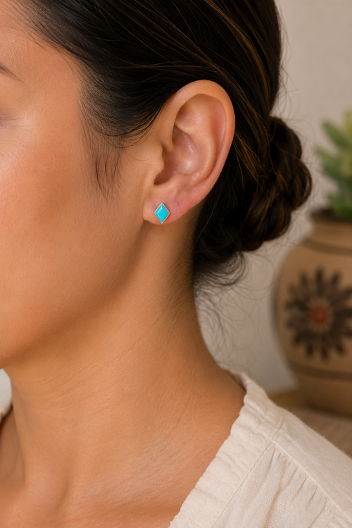 Petite Zuni Kingman turquoise stud earrings shown on ear, approximately 1/4 inch