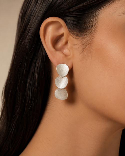 Sterling silver curved disc post earrings shown on ear