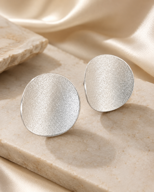 Sterling silver curved disc stud earrings with textured matte finish