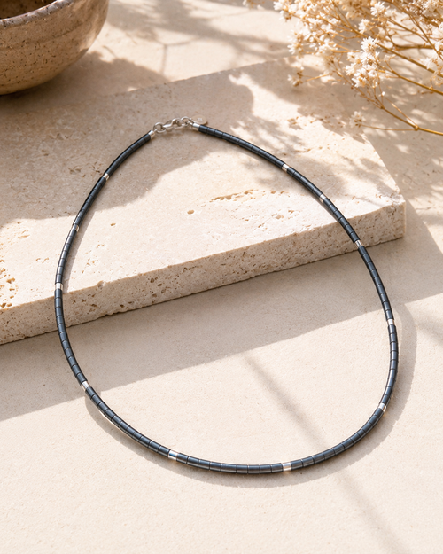 Close-up of grey hematite beads and sterling silver spacer accents on a handmade minimalist necklace.
