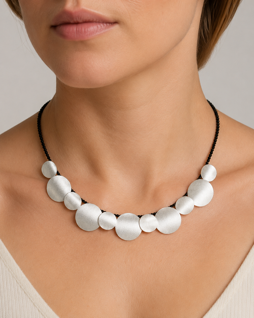 Sterling silver curved disc necklace with black onyx beads worn on neck
