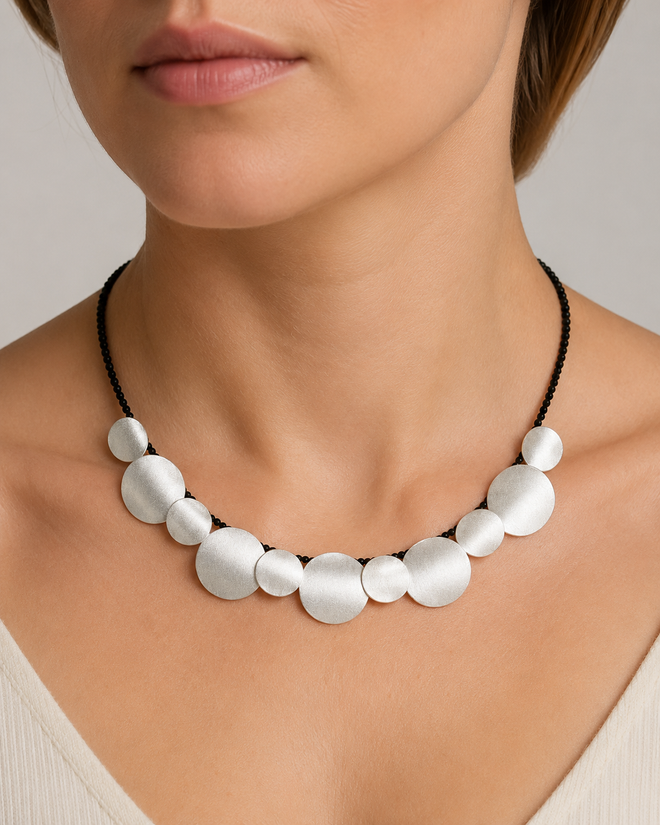 Sterling silver curved disc necklace with black onyx beads worn on neck