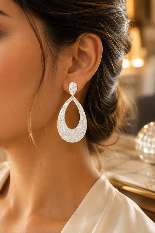 Woman wearing handmade hammered sterling silver statement earrings, lightweight contemporary silver earrings for everyday and special occasions.