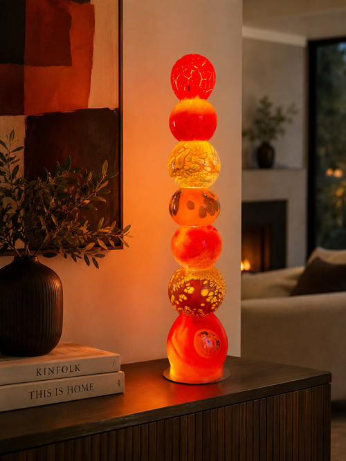 Warm-toned handblown glass light tower displayed as illuminated art lighting