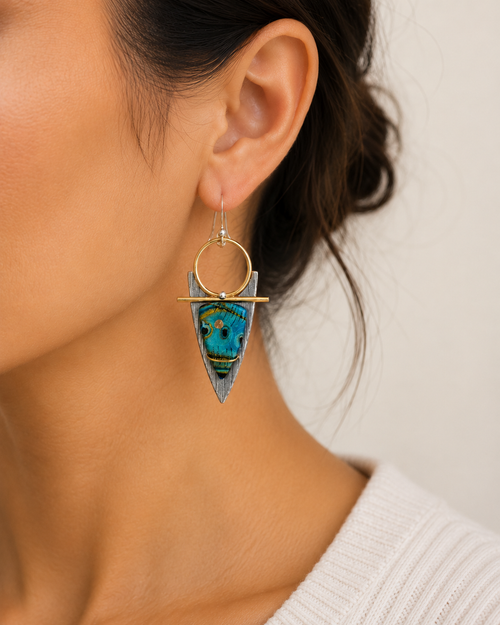 Turquoise color art glass statement earrings shown on model ear. Handmade artisan earrings in sterling silver and brass.