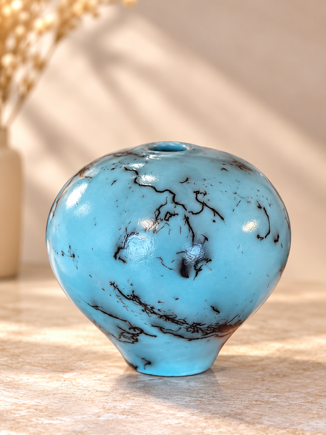 Turquoise horsehair raku orb pottery with rounded handmade ceramic form and organic black firing patterns