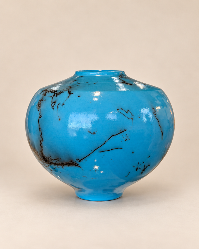Turquoise horsehair raku pot with rounded form and dramatic black fire lines