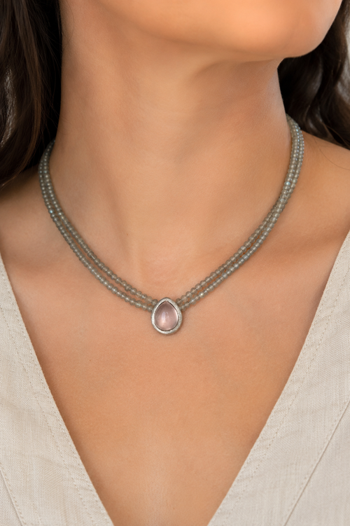 Woman wearing a handmade two strand Labradorite necklace with a 9x12mm pear-shaped Rose Quartz pendant in a matte dark sterling silver setting.