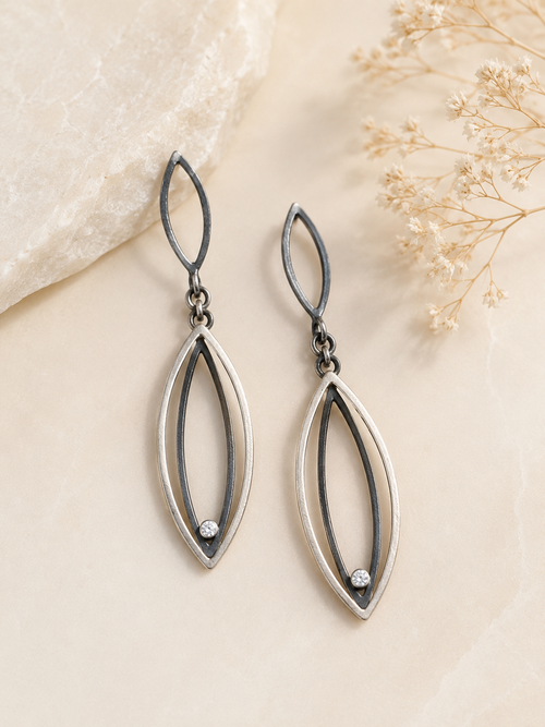 Two-tone sterling silver and oxidized sterling silver earrings with cubic zirconia shown on ear for size reference and styling inspiration.