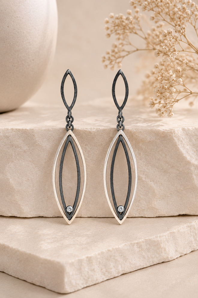 Two-tone sterling silver and oxidized sterling silver earrings with cubic zirconia accents handcrafted by an artisan and available at Raku Gallery in Jerome Arizona.