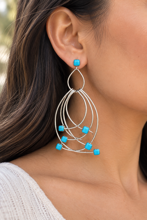 Zuni turquoise sterling silver dangle earring shown on ear, approximately 2 1/4 inches long